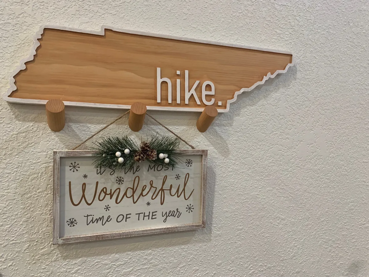 This image showcases a cheerful interior scene with a wooden sign that encourages guests to 'hike.' and another decorative sign reading 'It's the most Wonderful time of the year.' The setting suggests family activity and celebration, evoking a sense of togetherness and thoughtful hospitality.